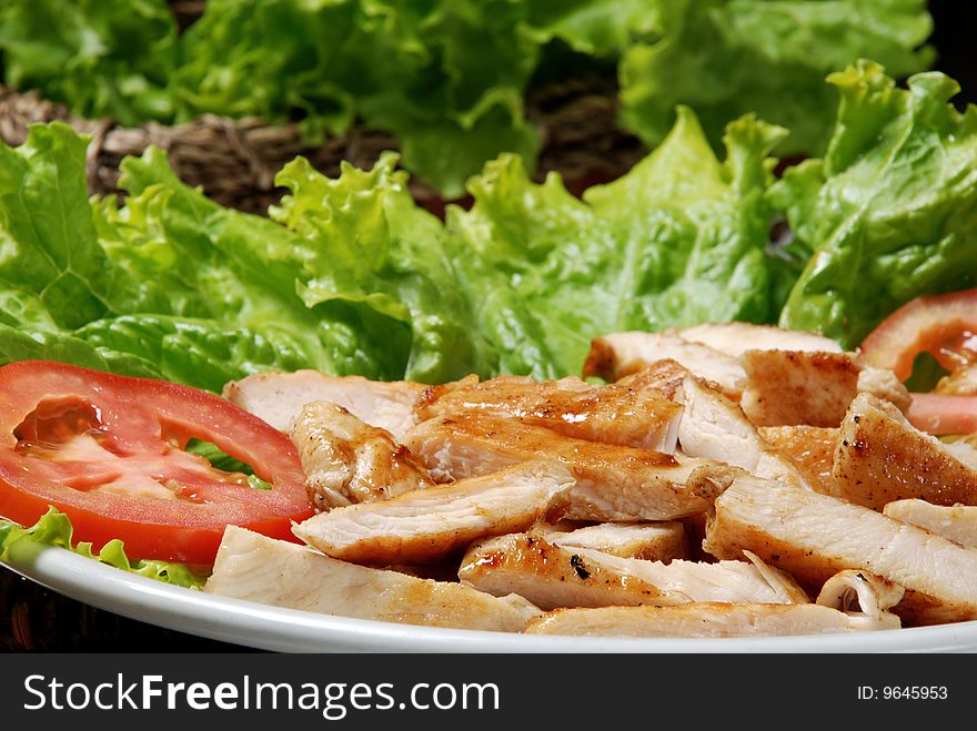 Plate of meat with tomato and lettuce. Plate of meat with tomato and lettuce