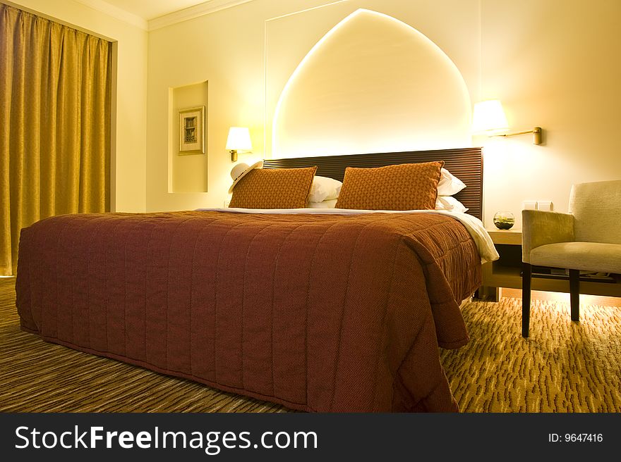 Inside of a luxurious hotel room with a Panama hat on the bed.