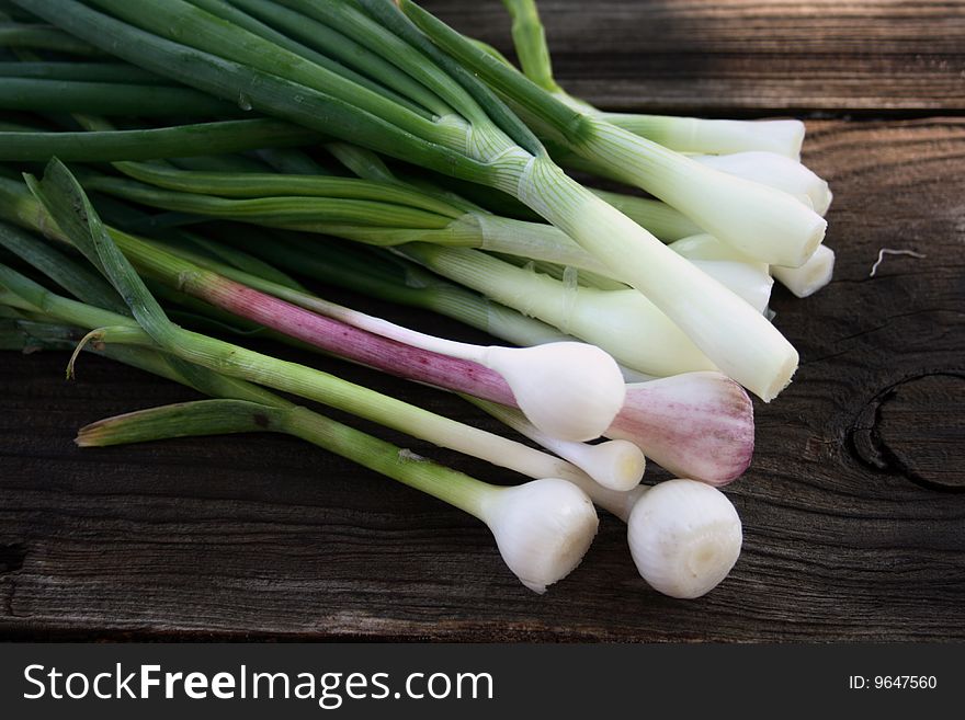 Young onion and garlic on weathering wooden table