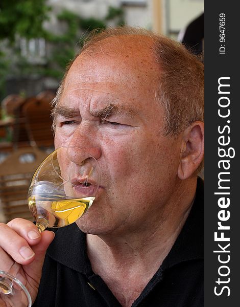 Mature man enjoying a glass of white wine. Mature man enjoying a glass of white wine