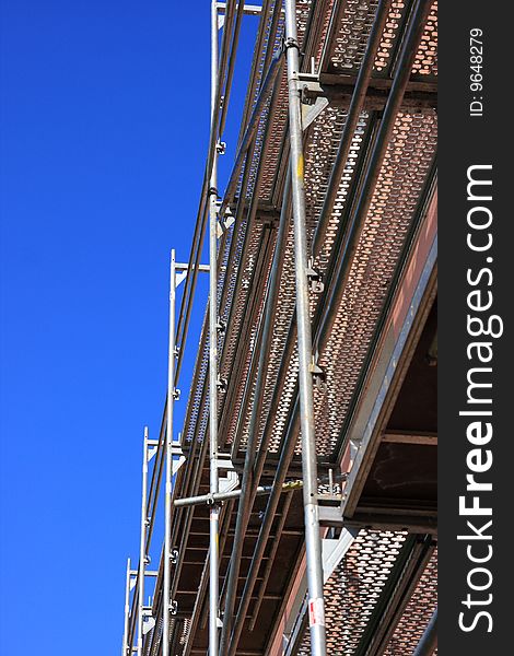Metal construction, scaffolding over blue, sky background