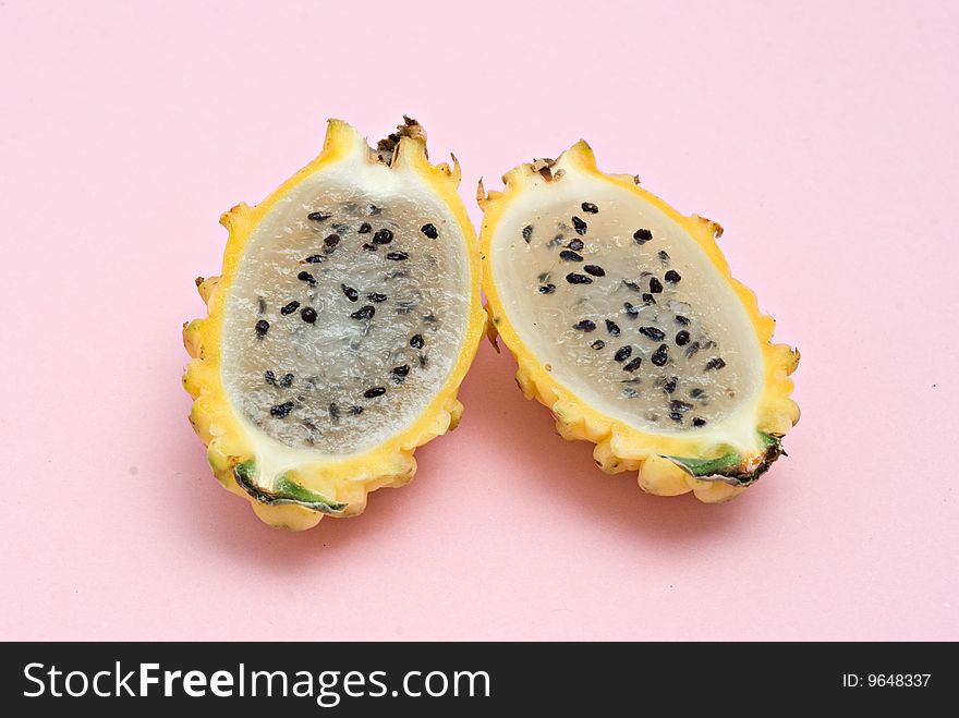 Yellow dragon fruit sections isolated on pink background