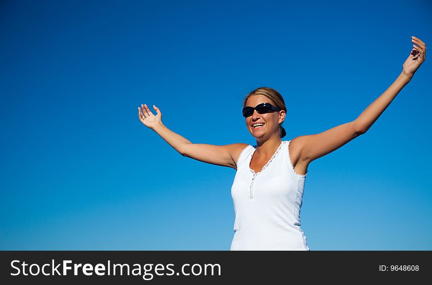 Beautiful woman with arms raised standing on beach. Beautiful woman with arms raised standing on beach