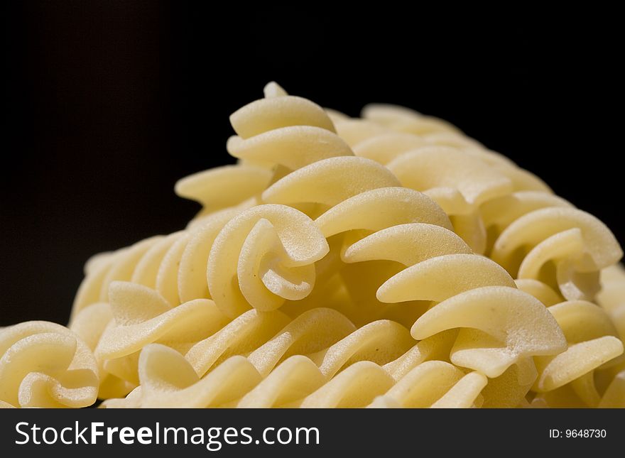 Close up of fusilli (pasta) over a black background. Close up of fusilli (pasta) over a black background