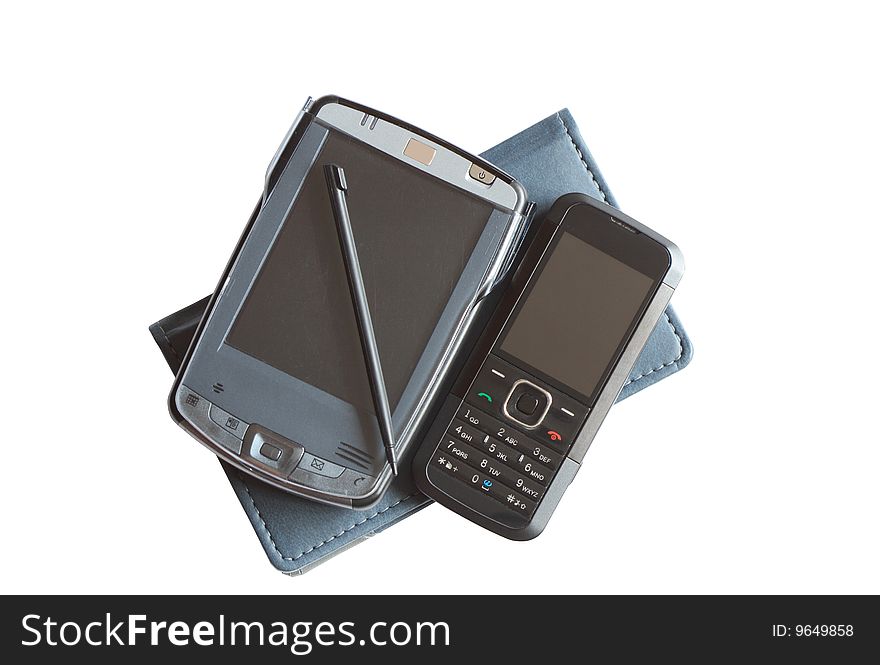 Pocket computer and mobile phone lying on notebook isolated with clipping path. Pocket computer and mobile phone lying on notebook isolated with clipping path