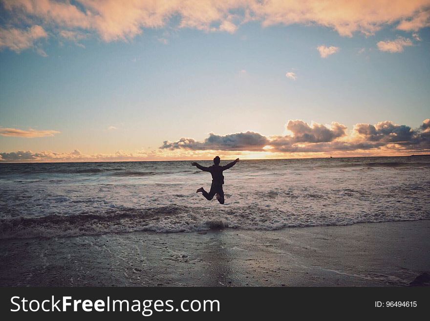 Person Taking Picture in Seashore during Sunset