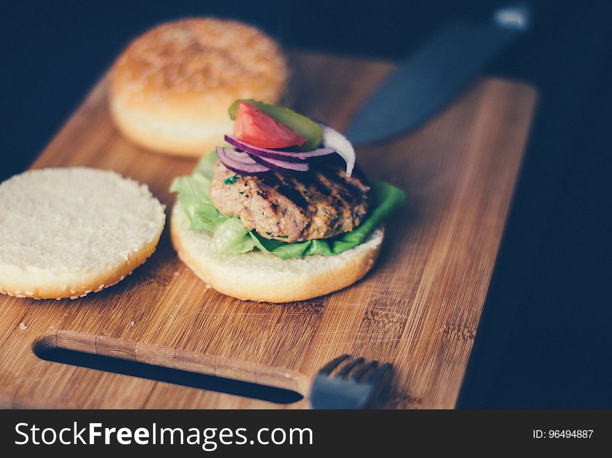 Shallow Focus Photography of Burger Sandwich Served on Brown Wooden Chopping Board