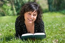 Smiling Girl Lying On A Meadow Reads A Book Stock Photo Smiling Girl Lying On A Meadow Reads A Book Stock Photo