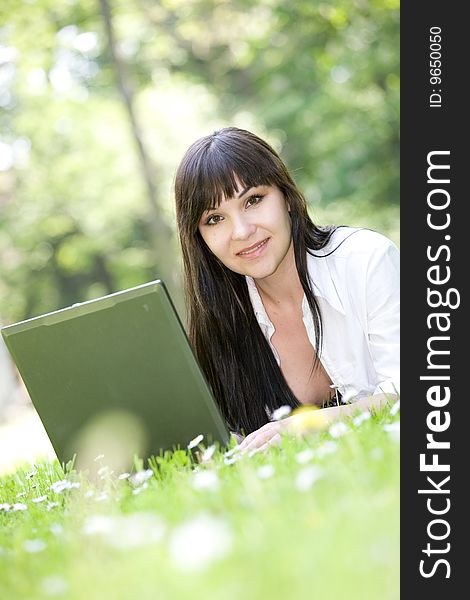 Happy woman relaxing on grass with laptop. Happy woman relaxing on grass with laptop