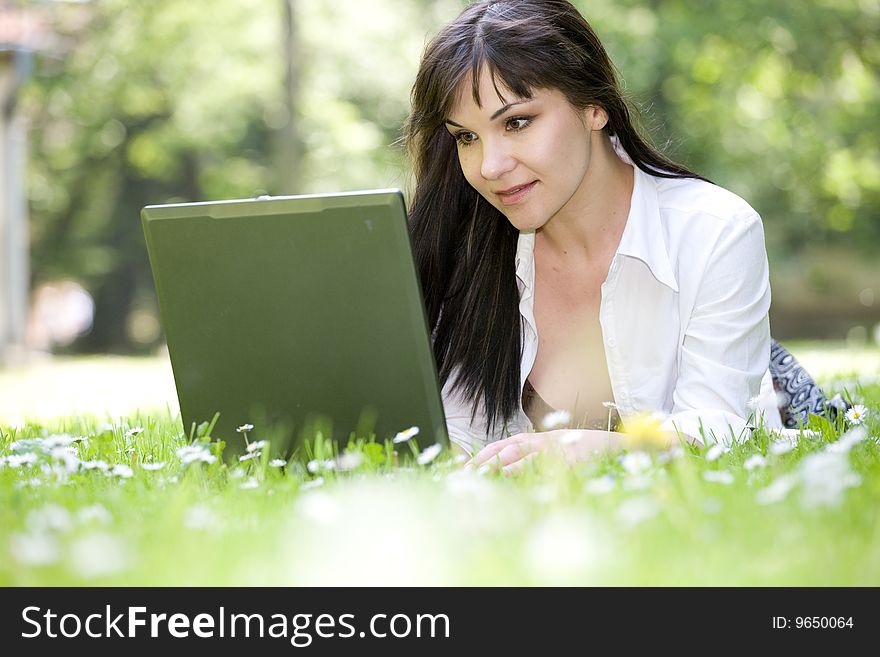 Happy woman relaxing on grass with laptop. Happy woman relaxing on grass with laptop