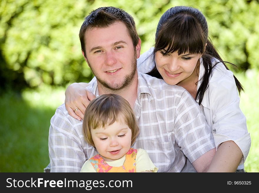 Mother, father and daughter relaxing together on grass. Mother, father and daughter relaxing together on grass