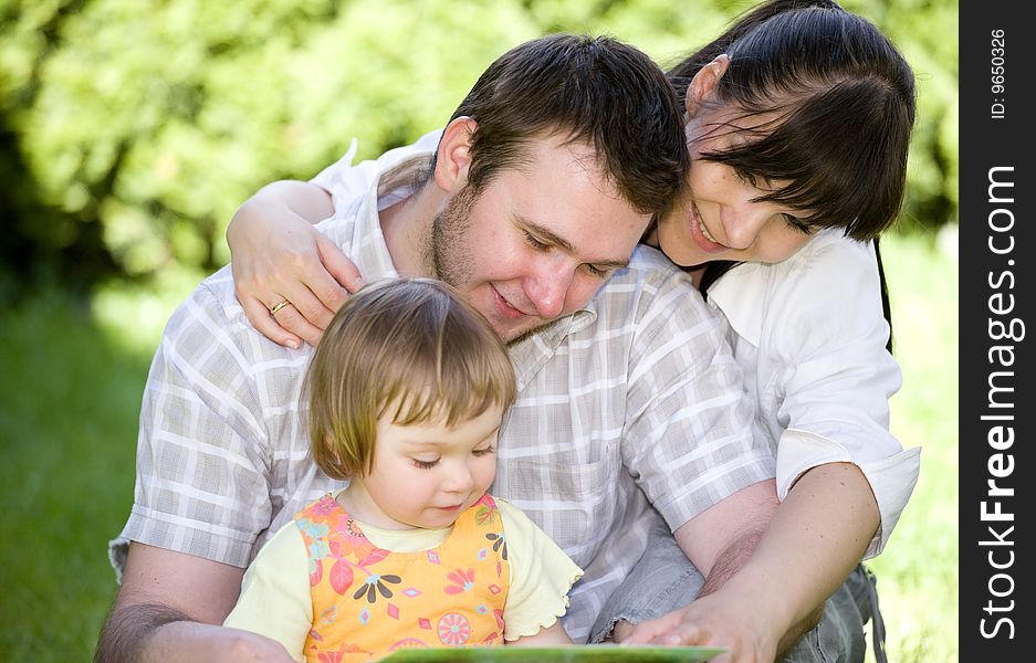 Mother, father and daughter relaxing together on grass. Mother, father and daughter relaxing together on grass