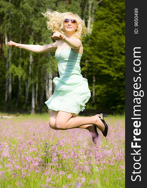 Young woman in pink flowers jumping