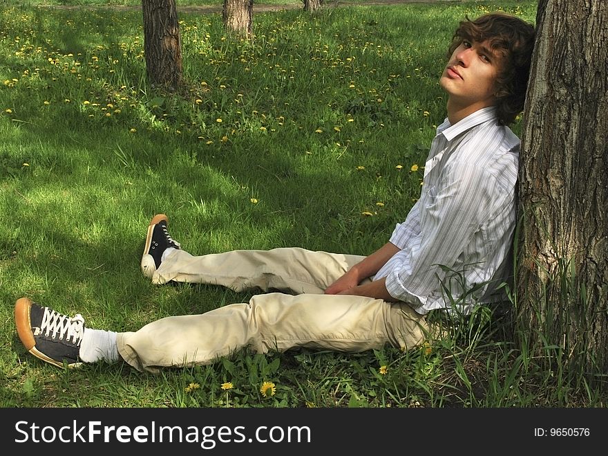 The young man near the tree. The young man near the tree