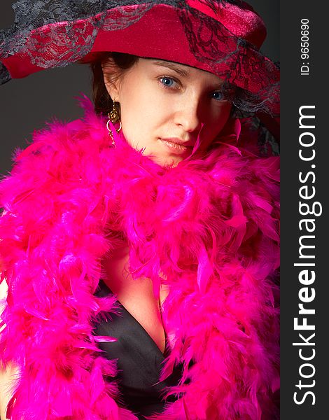 Beautiful woman in pink feathers and hat. Close-up view