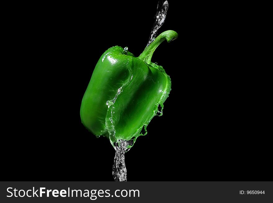 Green bulgarian pepper in water stream. Green bulgarian pepper in water stream