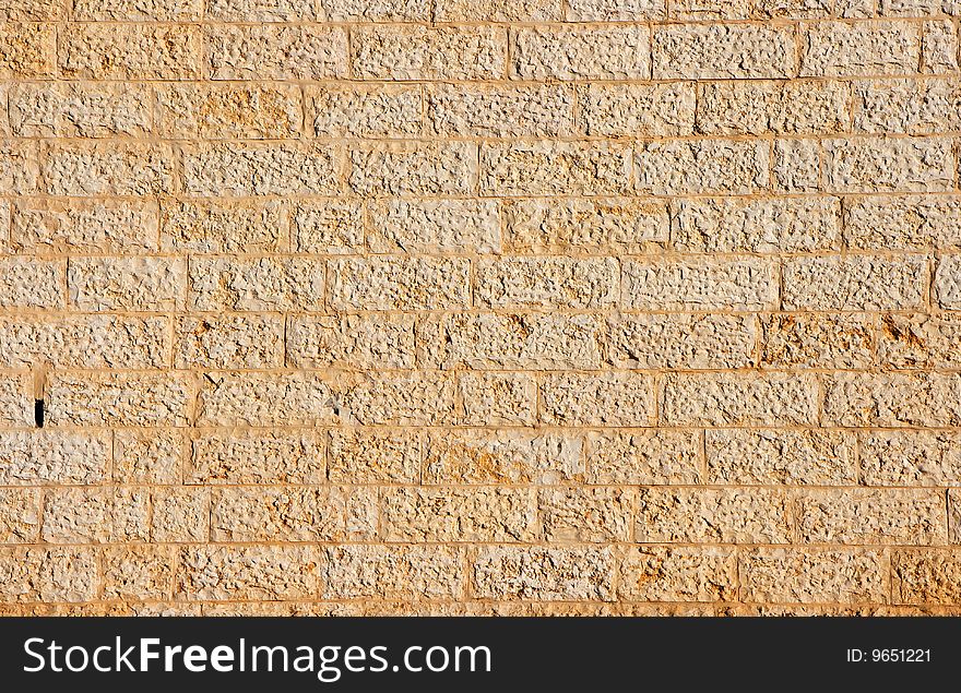 Wall built of yellow stone blocks