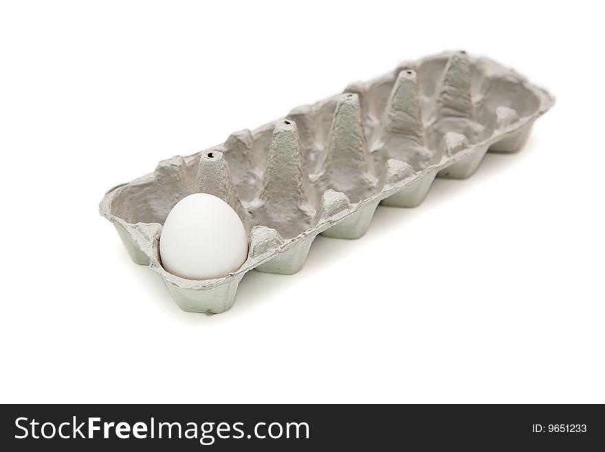 Single white egg in paper box isolated