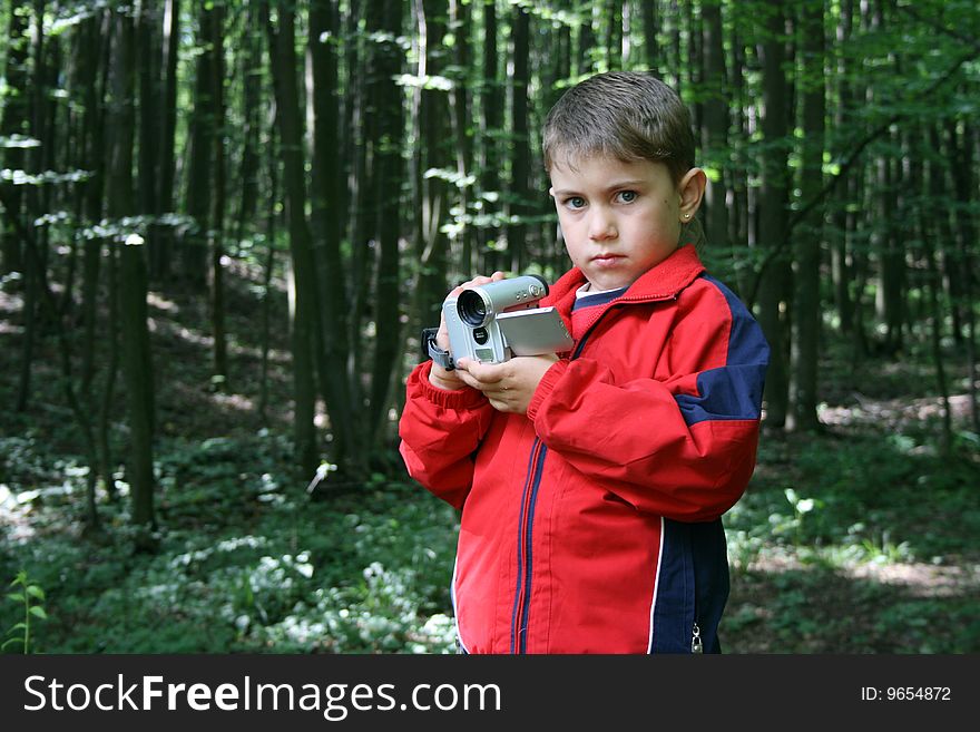 Boy with a red blouse and a camcorder on his hand. Boy with a red blouse and a camcorder on his hand