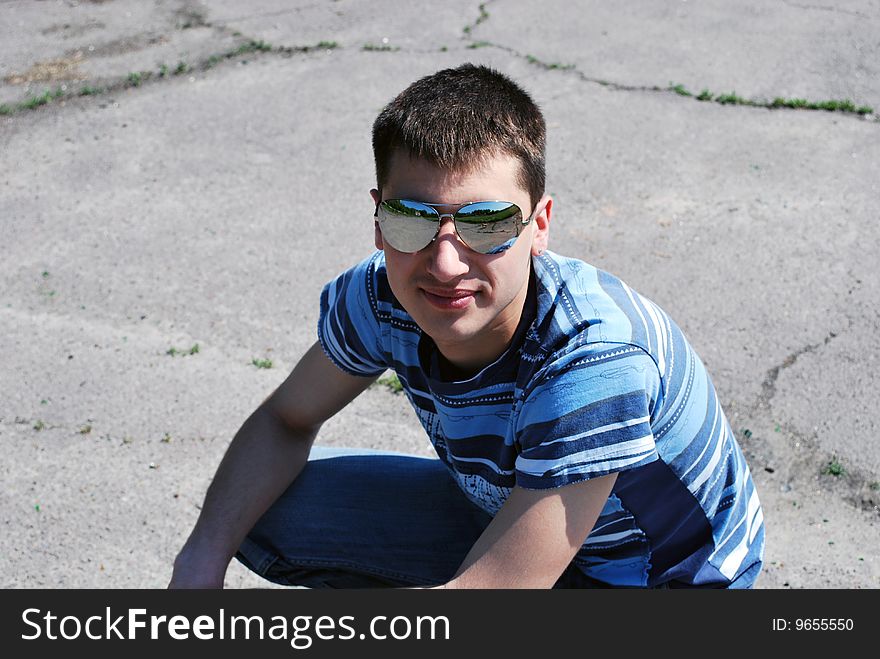 Young male wearing sunglasses and smiling. Young male wearing sunglasses and smiling
