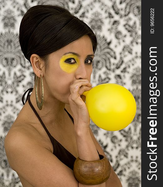 Beautiful asian model with funky make-up blow balloon. Beautiful asian model with funky make-up blow balloon