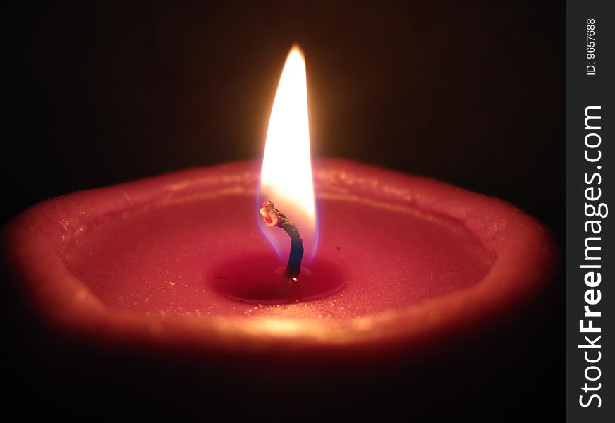 Burning candle on a dark background
