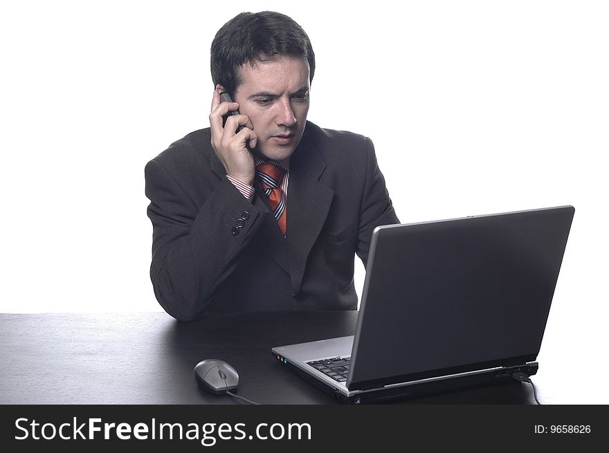 The businessman in a suit behind a table, with portable PC...