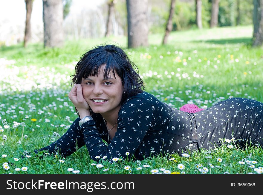 Smiling young woman lying on a flowery meadow. Smiling young woman lying on a flowery meadow