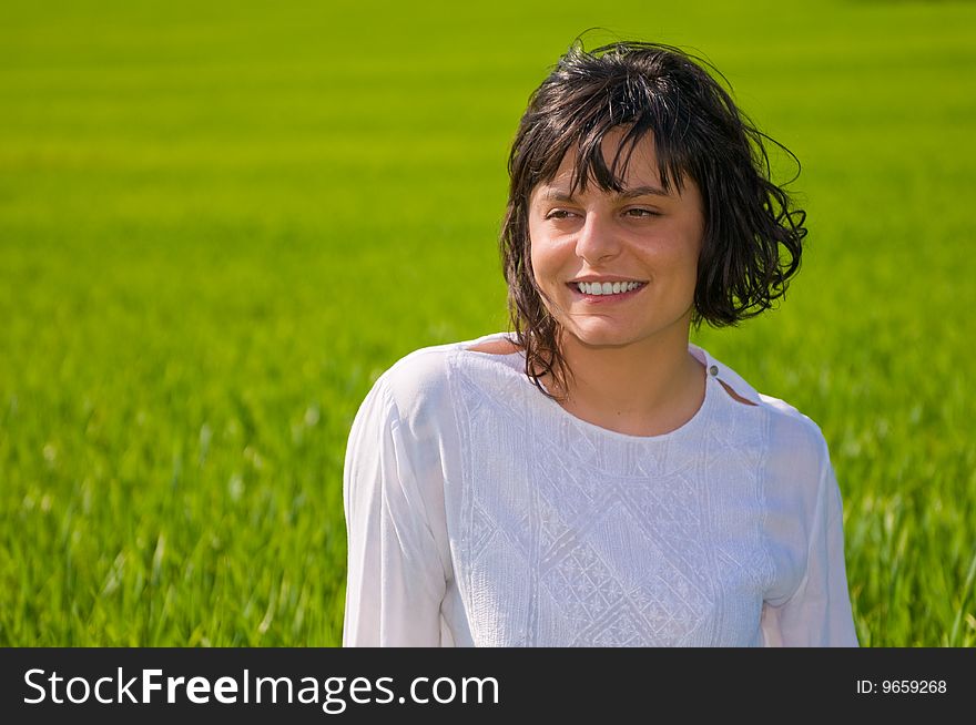 Closeup portrait of a beautiful young woman on green meadow. Closeup portrait of a beautiful young woman on green meadow
