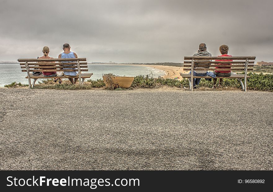 Two Couple Sitting on Bench Near Beach