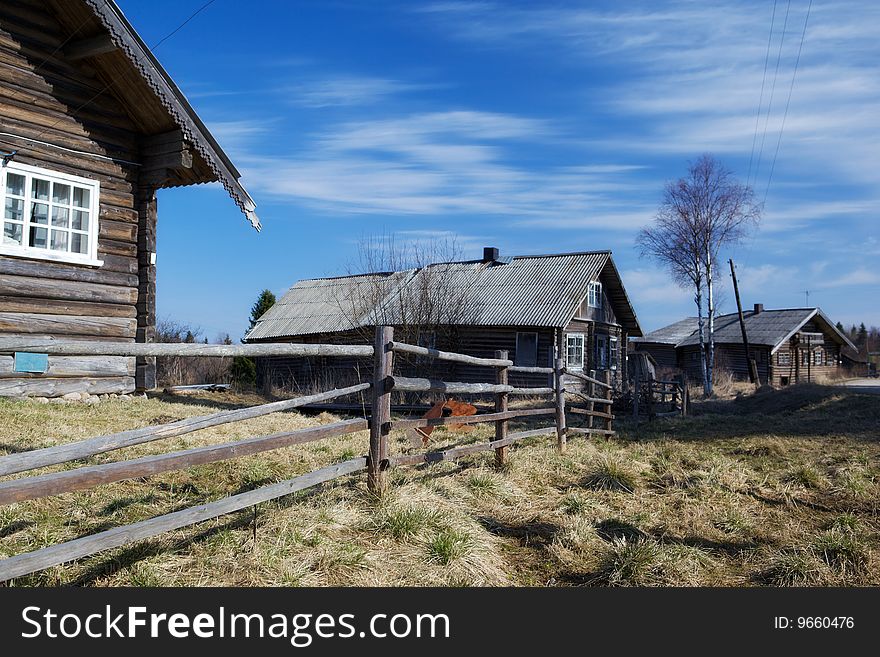 Photo of three rural houses. Spring. Village Kinerma in Kareliya, Russia.