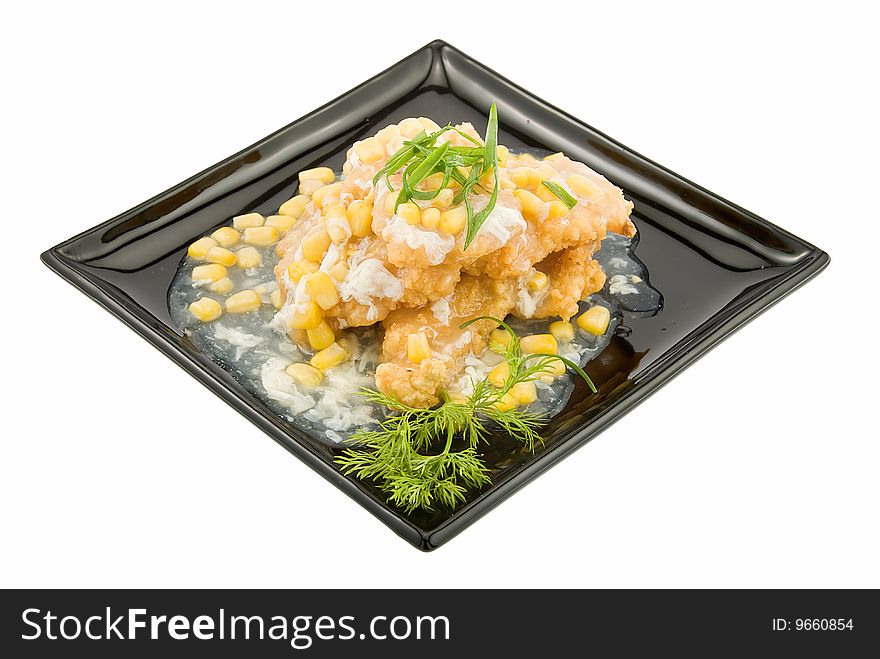 Black plate with pangasius under corns sauce