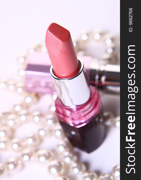 A red lipstick with perl on white