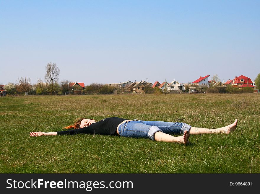 The girl lying on the grass exposing her face to the sun