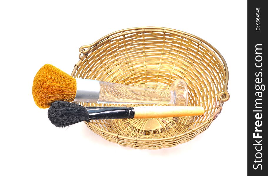 Makeup brushes in basket isolated on white background.