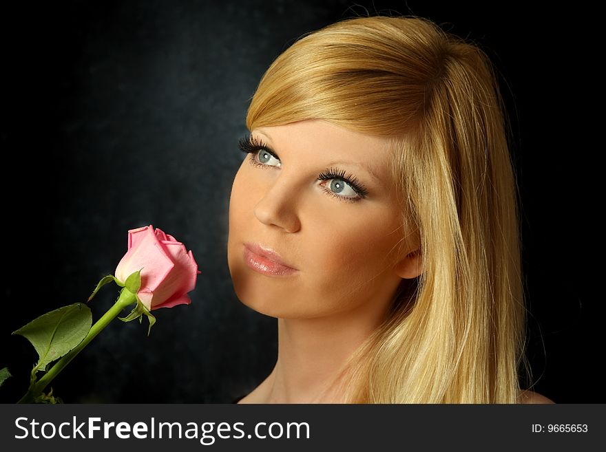 The beautiful girl with a flowing hair and a rose