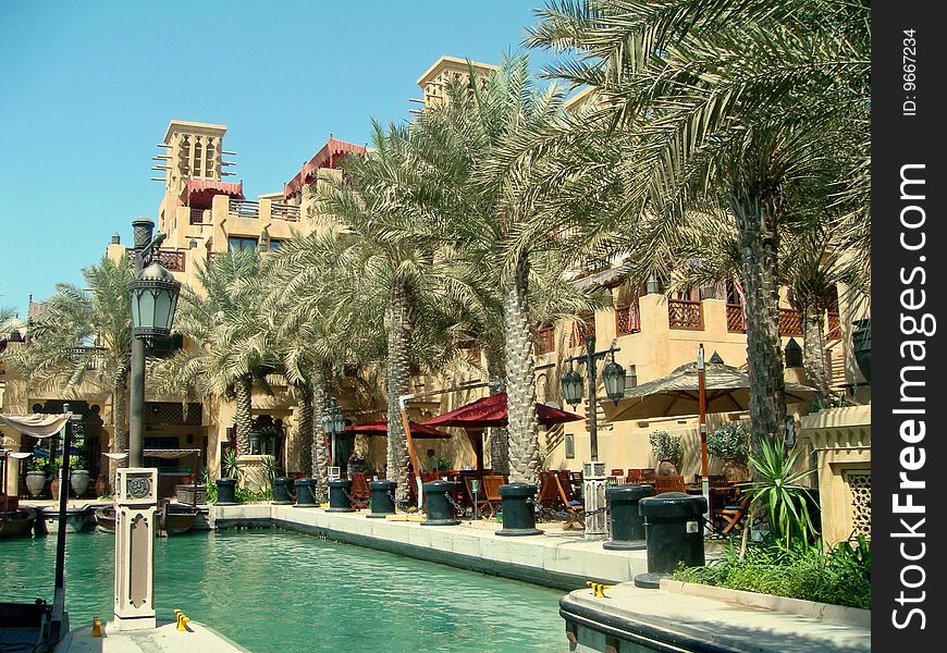 Palm trees lining the walkway at the Madinat Jumeirah with restaurants along the side. Palm trees lining the walkway at the Madinat Jumeirah with restaurants along the side