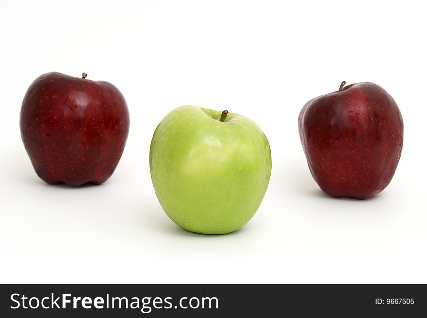 A green apple leads the other two red ones. A green apple leads the other two red ones.