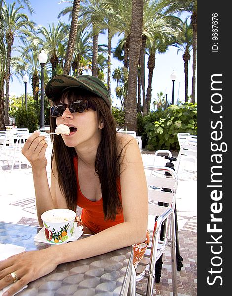 Woman with military hat and sun glasses eating ice cream. Woman with military hat and sun glasses eating ice cream