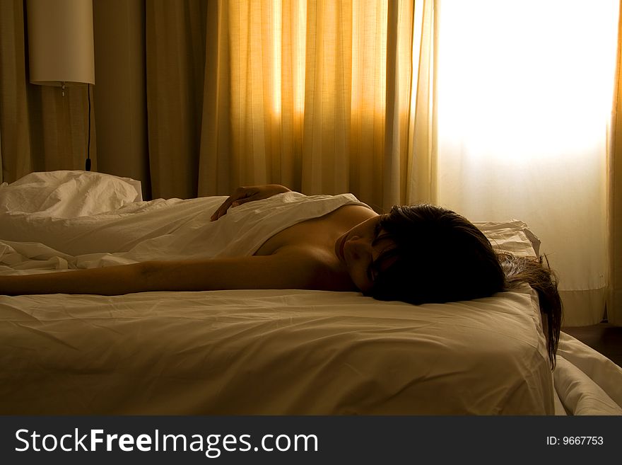 Woman sleeping with only the bed sheet covering her body. Woman sleeping with only the bed sheet covering her body