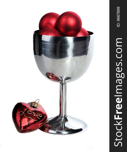 Silver wine goblet filled with red christmas decorations