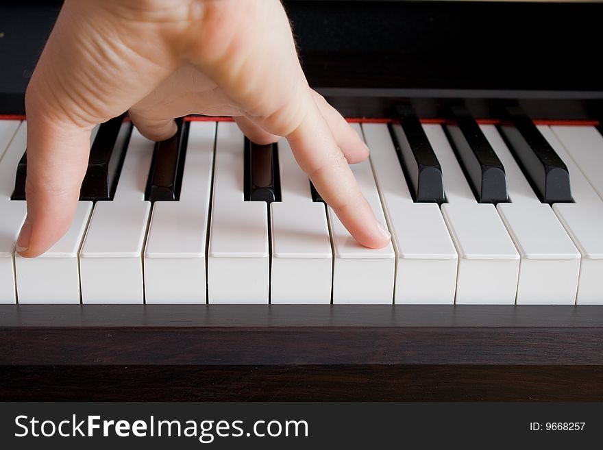 In a photo the hand of the pianist and a key of a piano is represented. In a photo the hand of the pianist and a key of a piano is represented.