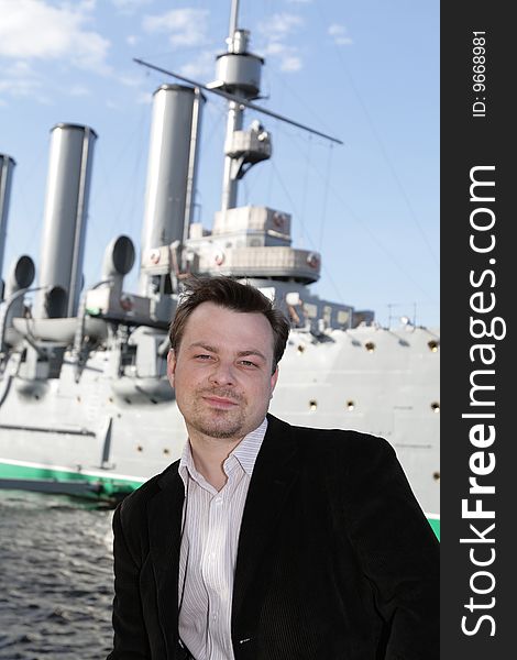 The man poses on a armoured cruiser background. The man poses on a armoured cruiser background