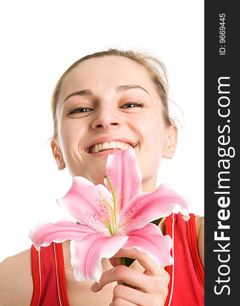 A smiling nice blond girl in red posing with a pink lily near her face on a white background. A smiling nice blond girl in red posing with a pink lily near her face on a white background