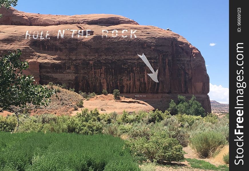 A massive rock with the message hole in the rock and a pointing arrow. A massive rock with the message hole in the rock and a pointing arrow.