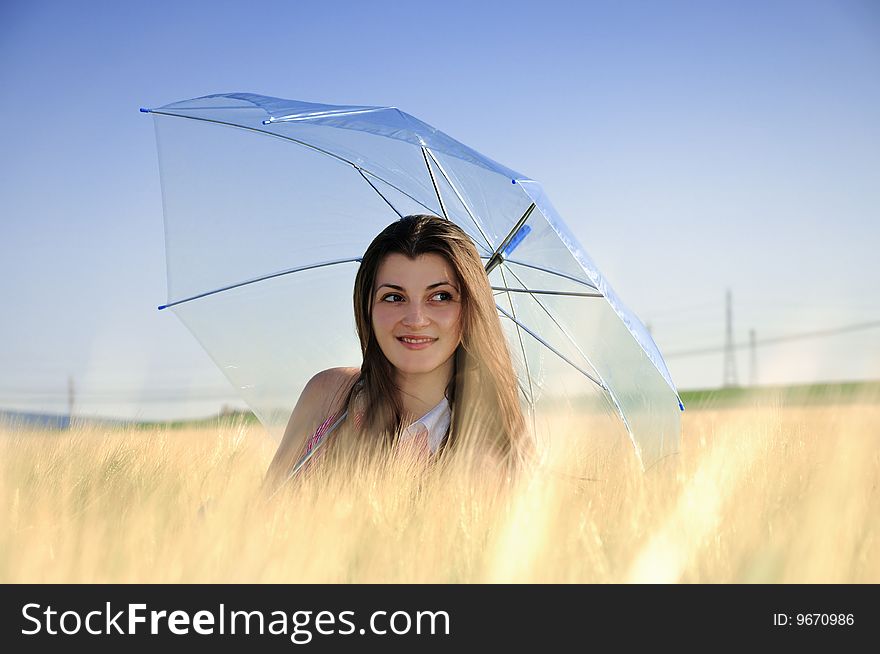 Smiling girl in field with umbrella. Smiling girl in field with umbrella