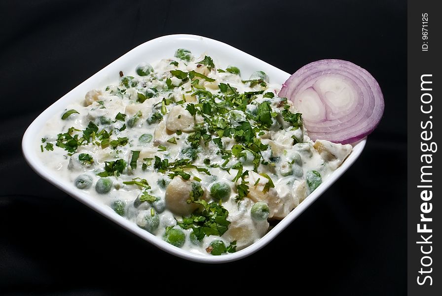 Baked Vegetable In A White Bowl With Onion Slice