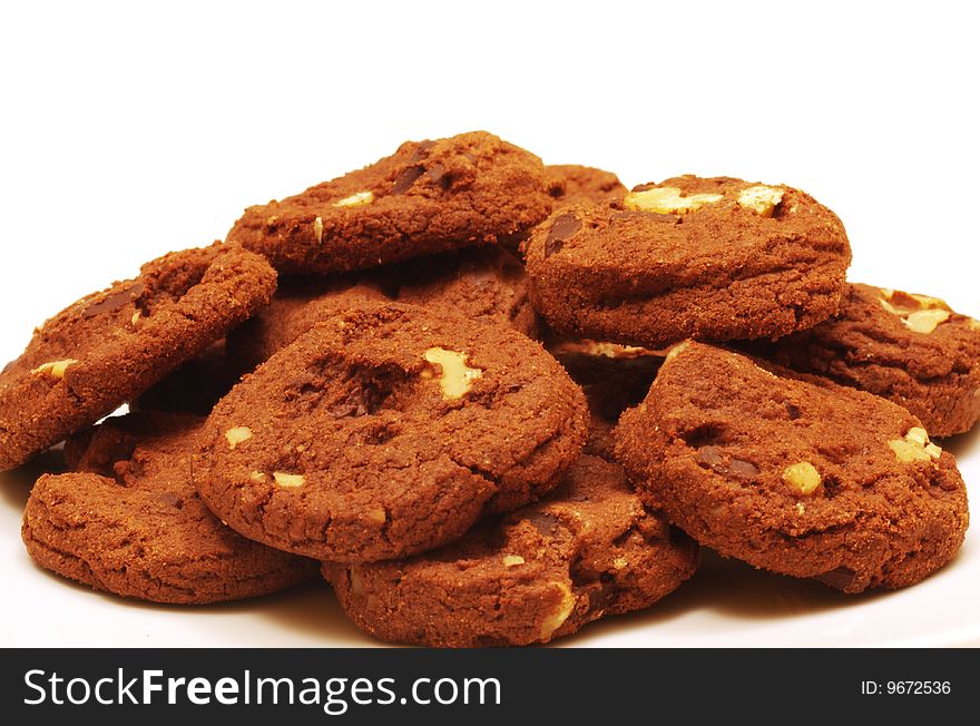 A bunch of delicious chocolate chip cookies with walnuts on a white background. A bunch of delicious chocolate chip cookies with walnuts on a white background