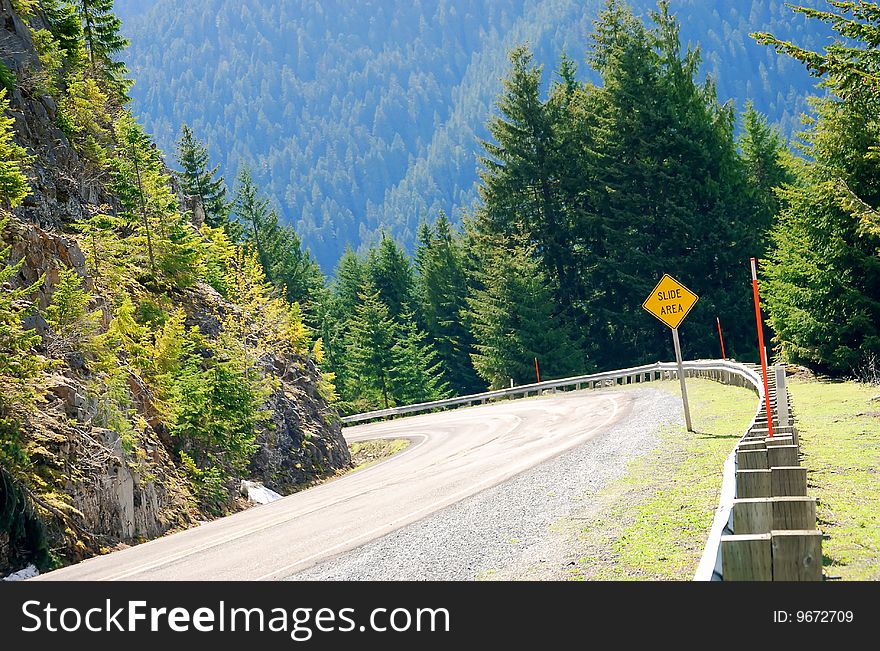 Slide area sign in the mountains road in North America. Slide area sign in the mountains road in North America.