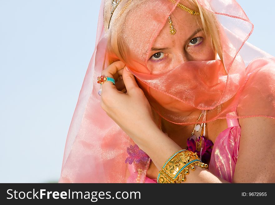 A woman cover her face with a pink asian dress close-up. A woman cover her face with a pink asian dress close-up